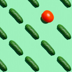 Fresh garden cucumbers on a colored green background, cucumbers with a red tomato. Farmer cucumber pattern. Food background.