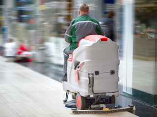Cleaning services worker with washing machine in supermarket shop clean and disinfect floor....