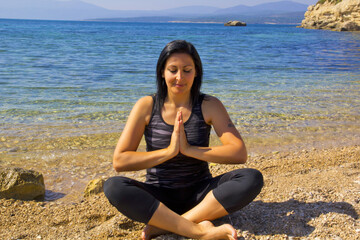Fototapeta na wymiar beautiful young woman meditating on the beach in Izmir Turkey 