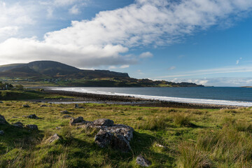 a view of Staffin village on the Isle of Skye with Quiraing Hills in the background.