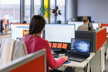 Business colleagues working at a busy open plan office. 