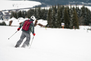 Unidentified tourist skiing in Flachau, the ski resort in Austria. Man in grey sportswear and with...