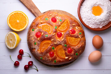 Coca de sant joan. Traditional San Juan cake to celebrate the arrival of summer in Spain made with brioche bread, candied fruit and nuts. - obrazy, fototapety, plakaty