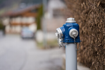 Blue water hydrant next to the the street on a sunny winter day
