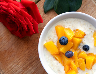 Oatmeal porridge with blueberries. Lovely breakfast with rose