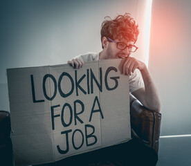depressed jobless man holding a looking for a job cardboard for unemployment problem concept.
