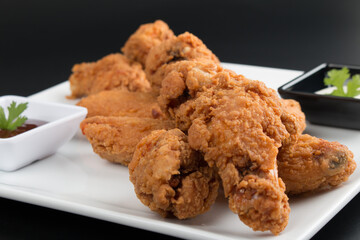 Dedos de pollo y alitas apanados con salsas para degustar en una entrada