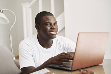 man african appearance at home in front of laptop fun chatting online
