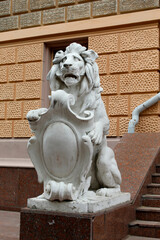 Lion statue. Coat of arms. White stone lion. Sculpture of an animal.