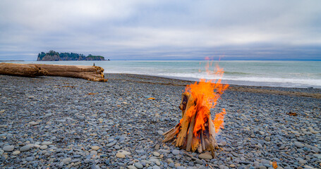 Fototapeta premium Campfire on the quiet beach in the evening. Rialto beach, Olympic National Park, Washington state.