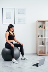 Balance workout. Sportive woman. Home training. Slim body. Healthy lifestyle. Smiling lady in black...