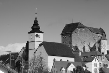 view of  ac hurch close to a medieval castle in monochroe