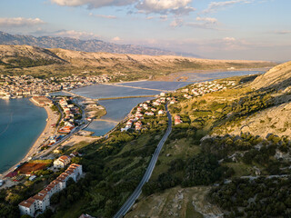 Aerial view of the town of Pag, on the island of Pag, Croatia. Seabed. Panoramic view of the city. Wild and desert nature. Headlands and cliffs of the Croatian coast. Houses on the sea at sunset