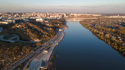 A beautiful river and a city on its banks. Evening park in Ufa. Beautiful sunset light. The clear sky is reflected in the water. Colorful landscape.