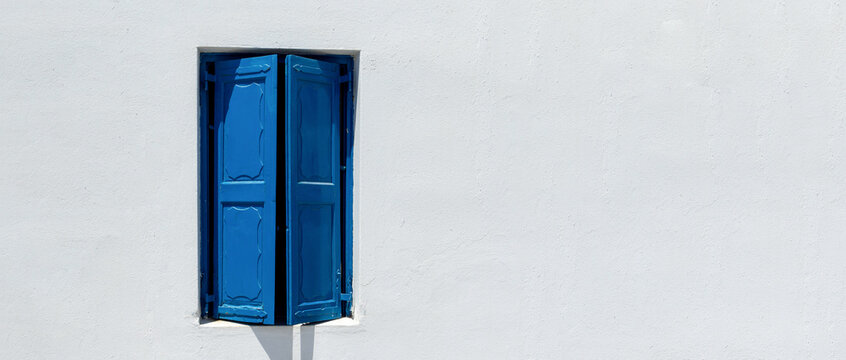  Blue Painted Exterior Shutters in a White washed Wall.