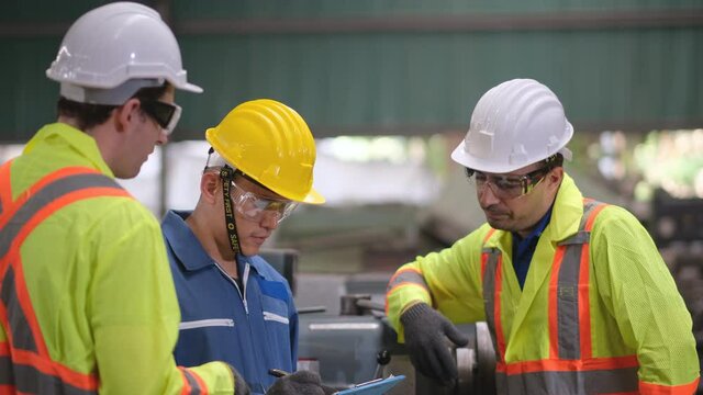 Three factory men or engineer workers discuss with serious emotion together about the problem of the machine. Industry and maintenance, teamwork in workplace and management system relate warehouse.
