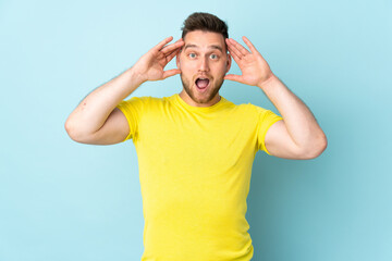 Russian handsome man isolated on blue background with surprise expression