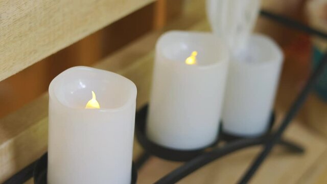 Close-up and selective focus 4K video of many plastic candle in a row with yellow light flickering as real candle for decoration in house shows clam and peace atmosphere for relaxing people.