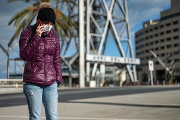 Fototapeta premium Portrait of a young girl talking on the phone in the street