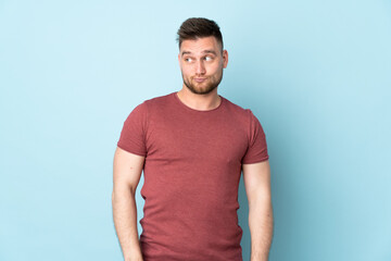 Obraz premium Russian handsome man over isolated background making doubts gesture looking side