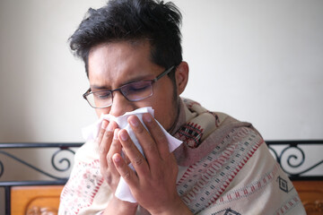 Sick man with flu blow nose with napkin.