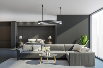 Grey bedroom interior with sofa and bed on concrete floor, mockup