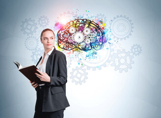 Attractive businesswoman wearing black suit holding a notebook and thinking about future career. Concept of business optimization, creativity and imagination. Colorful brain sketch with cog wheel