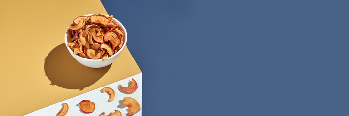 Crispy dried food. Organic tasty chips. Homemade snacks. Sliced apples. Healthy fruit. Two area. Orange pile. Trend natural dish. Horizontal banner. Copyspace