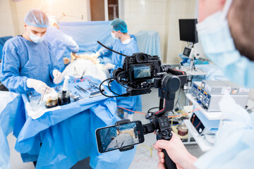 The videographer shoot the surgeon and assistants in the operating room with surgical equipment