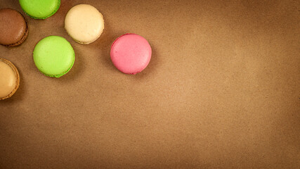 Macarons on brown chocolate background with copy space