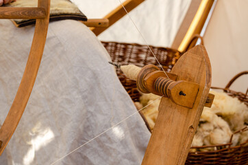 Close-up of renaissance woman processing wool on yarn. Medieval spinning wheel.