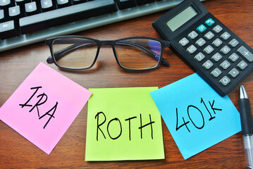 Selective focus of calculator, spectacle, sticky note written with IRA, ROTH , 401K.  Retirement, money, saving, investment, old, and awareness concept.