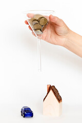 Model of a private house with a parked car and funnel with money over it. Money investments concept