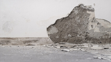 house renovation concept, wall in demolition with plaster rubble on floor, white background with copy space