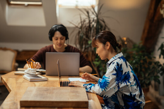 Asian Couple Working At Home Via Technology