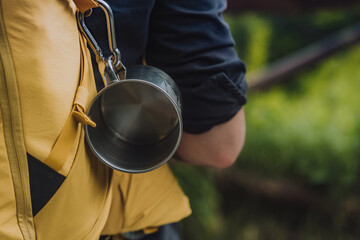 Cropped shot of camping gear, metal cup and a backpack