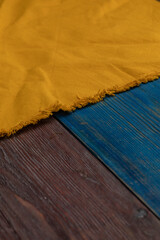 The yellow napkin on the two kinds of wooden table.