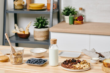 Fototapeta na wymiar Kitchen counter and shelves with kitchenware and table with food and milk