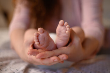 Obraz na płótnie Canvas Mother hands holding her adorable baby feet