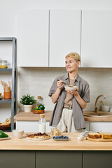 Fototapeta na wymiar A woman in casualwear having breakfast in a kitchen