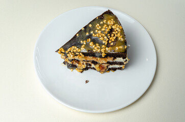 chocolate biscuit cake with nuts. with condensed milk on a white platter High quality photo