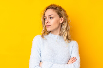 Fototapeta premium Young blonde woman isolated on yellow background portrait
