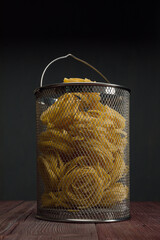 Pasta tagliatelle in the boiling basket.