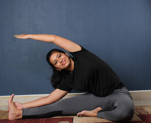 Smiling Indian woman practicing yoga at home. international yoga day