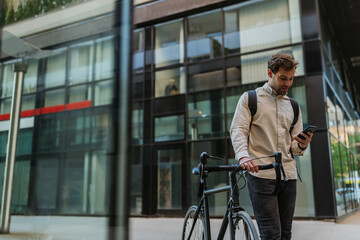 Businessman commuting to work with his bicycle and using phone