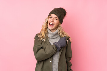 Young girl with winter hat isolated on pink background celebrating a victory