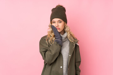 Young girl with winter hat isolated on pink background unhappy and frustrated