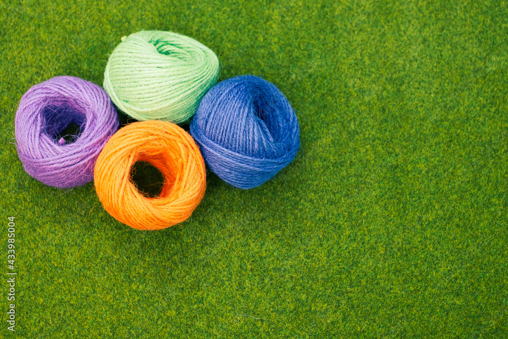 Poster top view of colorful thread yarns on the grass with a copy space