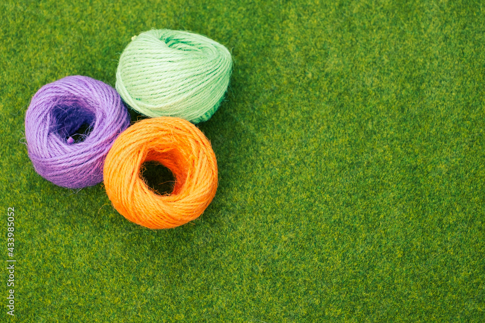 Poster top view of colorful thread yarns on the grass with a copy space