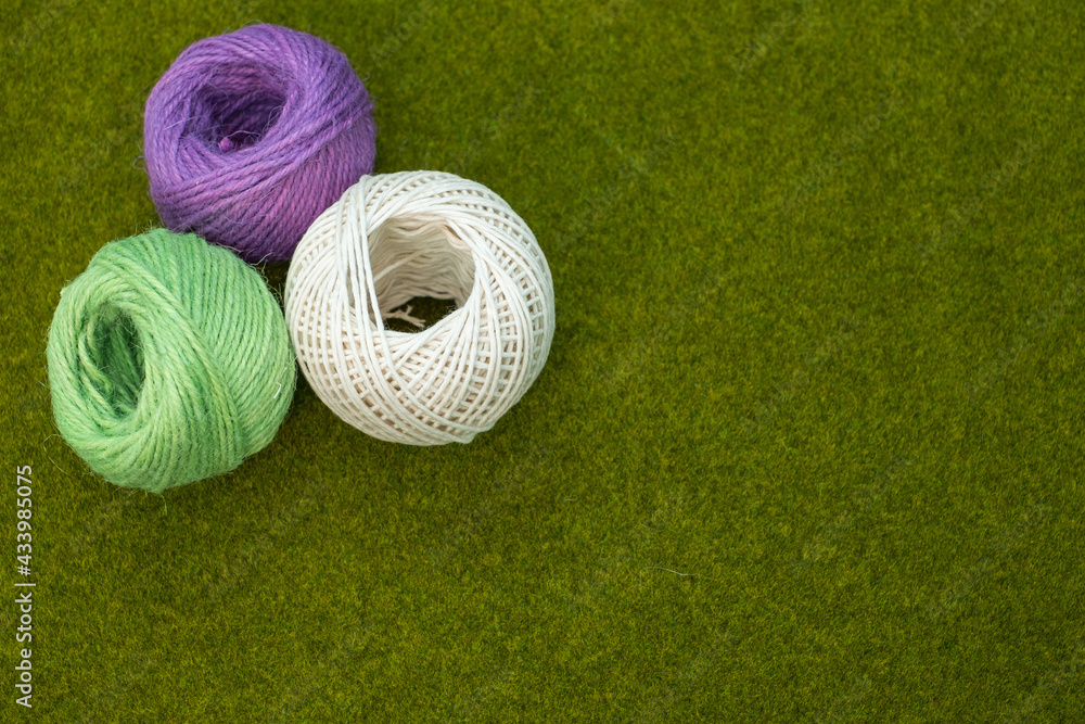 Poster top view of colorful thread yarns on the grass with a copy space